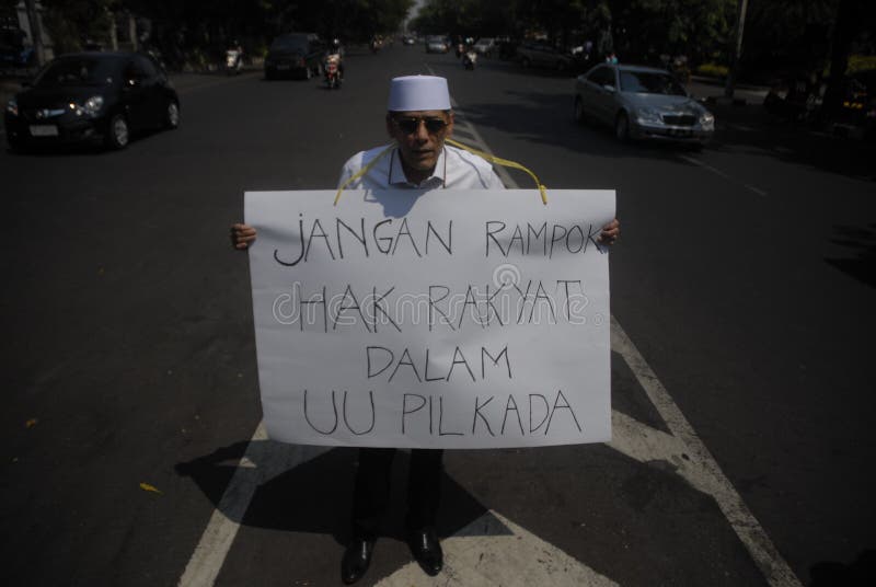 Indonesian Politician Hasan Mulachela shows a poster to support direct election, on a single-man protest in Solo, Java, Indonesia. Indonesia’s parliament has voted unanimously to reinstate direct elections months after the previous round of lawmakers voted to scrap them. Indonesian Politician Hasan Mulachela shows a poster to support direct election, on a single-man protest in Solo, Java, Indonesia. Indonesia’s parliament has voted unanimously to reinstate direct elections months after the previous round of lawmakers voted to scrap them.