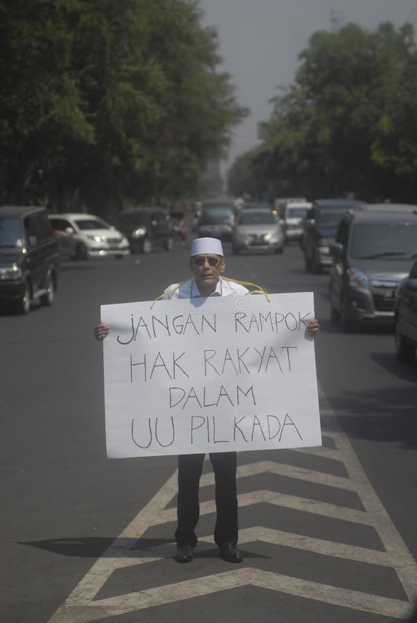 Indonesian Politician Hasan Mulachela shows a poster to support direct election, on a single-man protest in Solo, Java, Indonesia. Indonesia’s parliament has voted unanimously to reinstate direct elections months after the previous round of lawmakers voted to scrap them. Indonesian Politician Hasan Mulachela shows a poster to support direct election, on a single-man protest in Solo, Java, Indonesia. Indonesia’s parliament has voted unanimously to reinstate direct elections months after the previous round of lawmakers voted to scrap them.