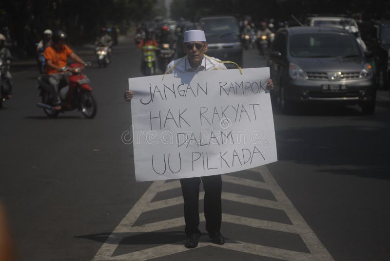 Indonesian Politician Hasan Mulachela shows a poster to support direct election, on a single-man protest in Solo, Java, Indonesia. Indonesia’s parliament has voted unanimously to reinstate direct elections months after the previous round of lawmakers voted to scrap them. Indonesian Politician Hasan Mulachela shows a poster to support direct election, on a single-man protest in Solo, Java, Indonesia. Indonesia’s parliament has voted unanimously to reinstate direct elections months after the previous round of lawmakers voted to scrap them.