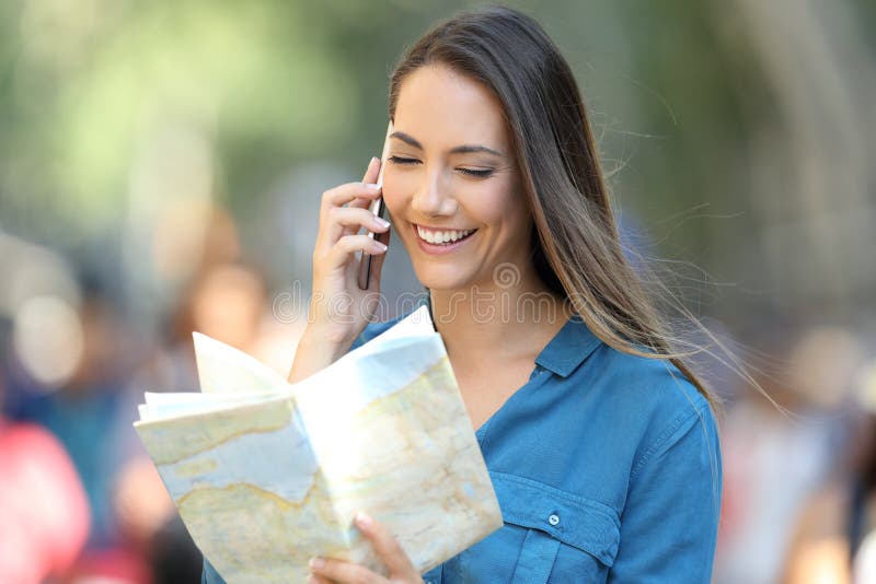 L'information demandante de touristes heureuse au téléphone images libres de droits L'information demandante de touristes heureuse au téléphone images libres de droits