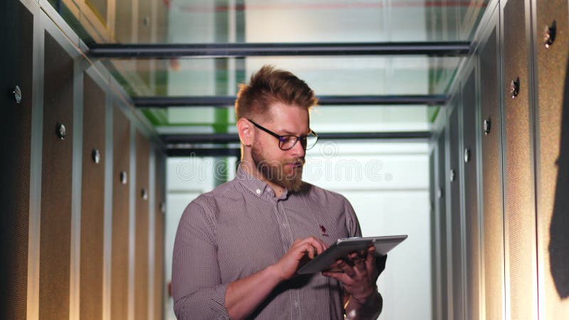 L'ingegnere informatico lavora con il Tablet PC durante il controllo dei computer nel centro dati