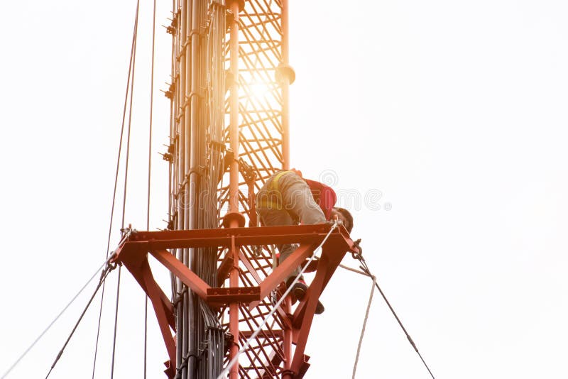 L'ingegnere o il tecnico che lavora all'alta torre, lavoro di rischio di alto lavoro, la gente sta lavorando con l'attrezzatura d fotografia stock L'ingegnere o il tecnico che lavora all'alta torre, lavoro di rischio di alto lavoro, la gente sta lavorando con l'attrezzatura d fotografia stock