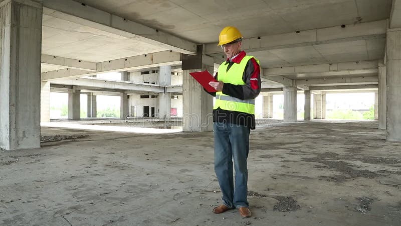 L'ingénieur dans le casque jaune reste sur le chantier de construction