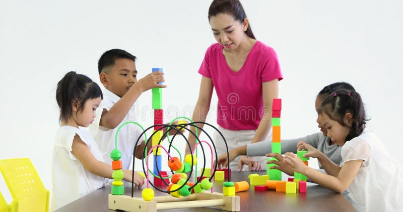 L'insegnante gioca i blocchi di legno variopinti con lo studente stock footage