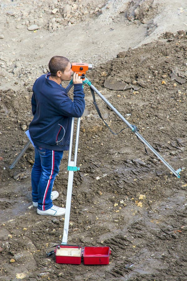 L'ispettore effettua le misure con l'aiuto di un livello workplace fotografia stock libera da diritti L'ispettore effettua le misure con l'aiuto di un livello workplace fotografia stock libera da diritti