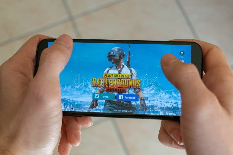 L'Italia, Roma - 7 marzo 2019: Mani che tengono uno smartphone con il gioco mobile dei campi di battaglia di PUBG sullo schermo d fotografia stock L'Italia, Roma - 7 marzo 2019: Mani che tengono uno smartphone con il gioco mobile dei campi di battaglia di PUBG sullo schermo d fotografia stock