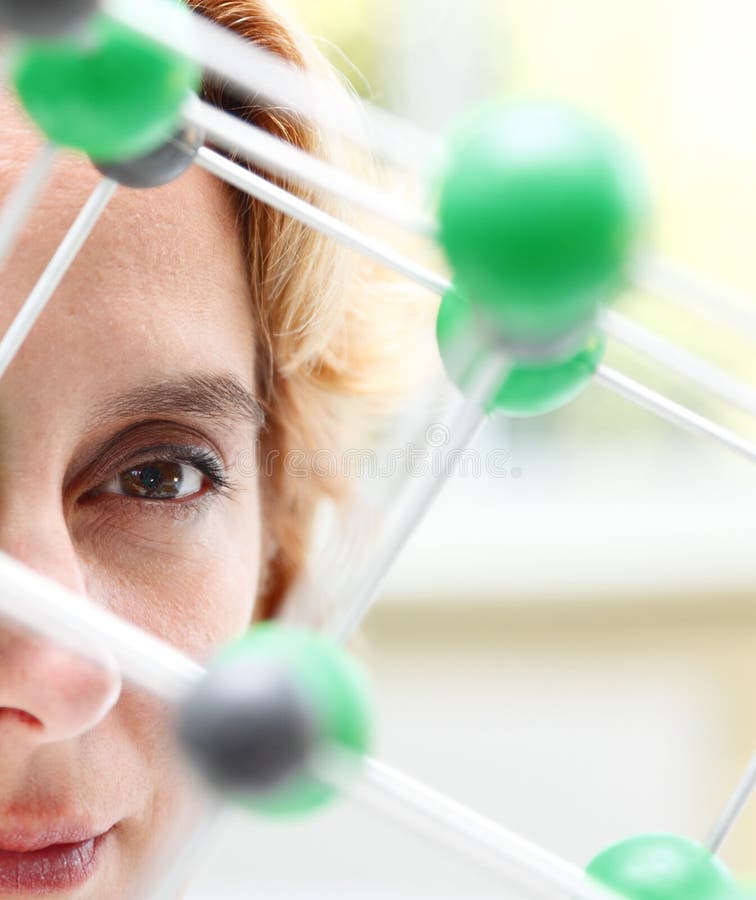 Image of a female researcher eye through a molecular model structure.Selctive focus on the eye. Image of a female researcher eye through a molecular model structure.Selctive focus on the eye.