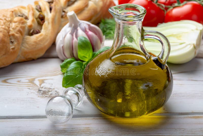 L'olio d'oliva naturale del vergine è bottiglia di vetro, servita con alimento Mediterraneo tradizionale