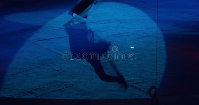 L'ombre d'un homme faisant la gymnastique de roue sous les projecteurs du cirque 4k banque de vidéos