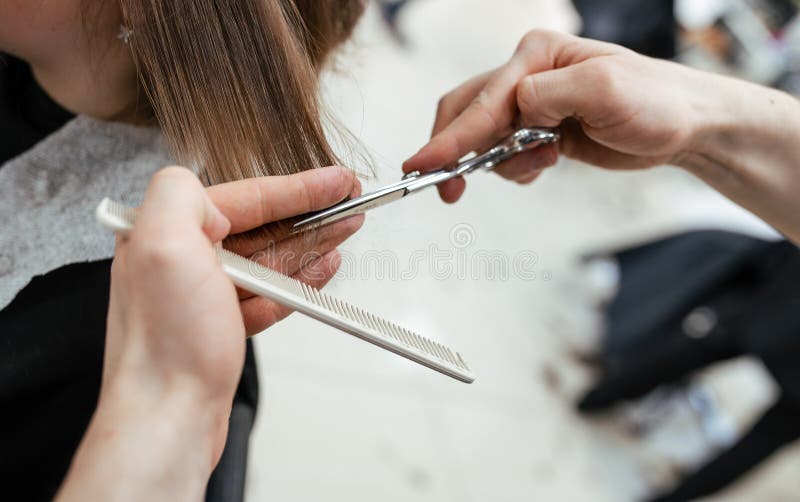 L'opera di un parrucchiere. parrucchiere ha tagliato i capelli a una donna in un salone di bellezza. chiusura delle mani