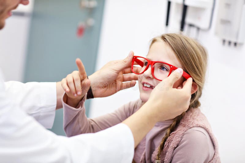 L'optometrista maschio del bambino esamina la vista della bambina immagine stock libera da diritti
