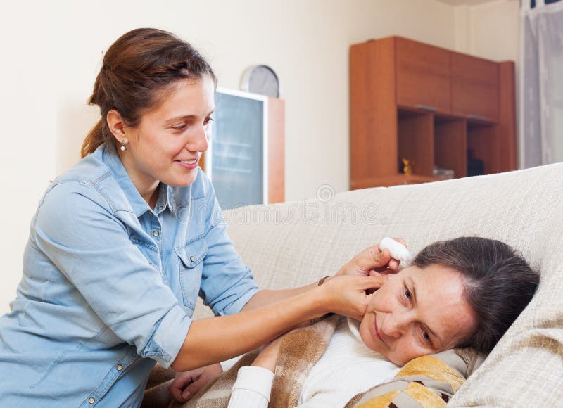 L'oreille adulte d'égoutture de fille se laisse tomber à sa mère images stock L'oreille adulte d'égoutture de fille se laisse tomber à sa mère images stock