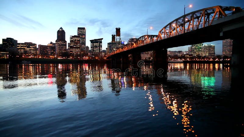 L'orizzonte del centro della città di Portland Oregon lungo il fiume di Willamette con Hawthorne Bridge e l'ora blu innaffiano le