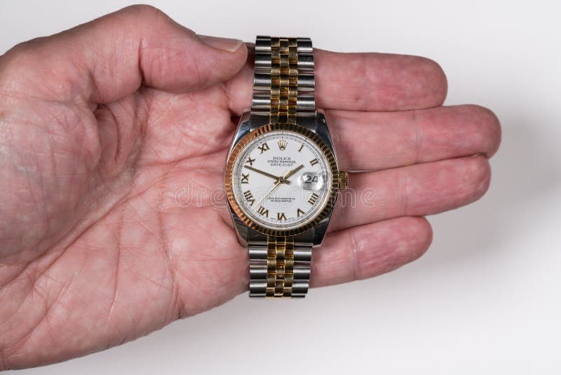 MORGANTOWN, WV - 24 JULY 2018: Rolex Oyster Perpetual Datejust gold watch in senior man`s hand. MORGANTOWN, WV - 24 JULY 2018: Rolex Oyster Perpetual Datejust gold watch in senior man`s hand