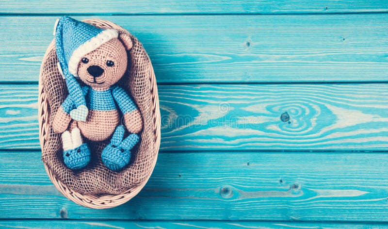 L'petit animal d'ours mou se situe dans le panier Ours de nounours tricoté dans le chapeau photographie stock L'petit animal d'ours mou se situe dans le panier Ours de nounours tricoté dans le chapeau photographie stock