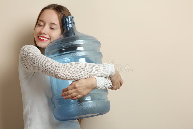 L ragazza che abbraccia una grande bottiglia di acqua immagine stock L ragazza che abbraccia una grande bottiglia di acqua immagine stock