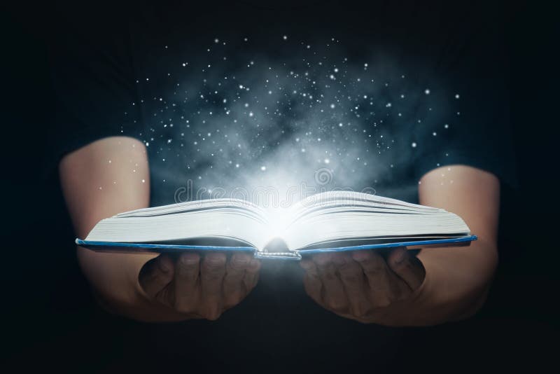 L'uomo apre un libro magico con luci in crescita e polvere magica che galleggia sul libro l'educazione il sapere e la religione immagini stock