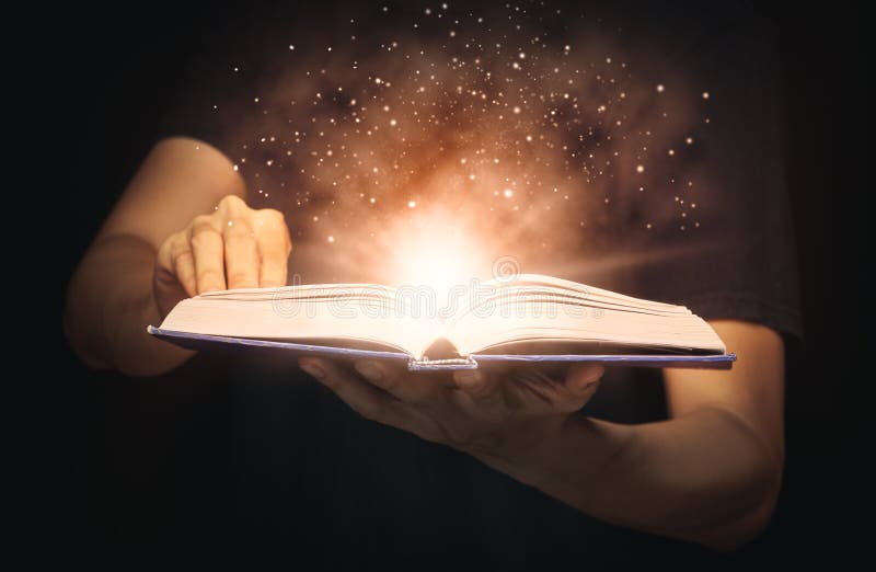 L'uomo apre un libro magico con luci in crescita e polvere magica che galleggia sul libro l'educazione il sapere e la religione fotografie stock libere da diritti