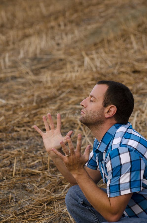 L'uomo con le mani ha sollevato nel culto e nell'elogio immagine stock L'uomo con le mani ha sollevato nel culto e nell'elogio immagine stock
