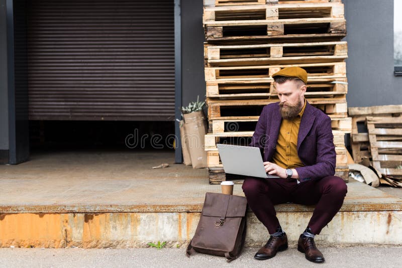 L'uomo d'affari bello nello stile d'annata copre lavorare al computer portatile immagini stock L'uomo d'affari bello nello stile d'annata copre lavorare al computer portatile immagini stock