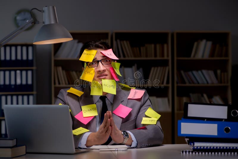 L'uomo d'affari che resta tardi per selezionare le priorità fotografie stock libere da diritti L'uomo d'affari che resta tardi per selezionare le priorità fotografie stock libere da diritti