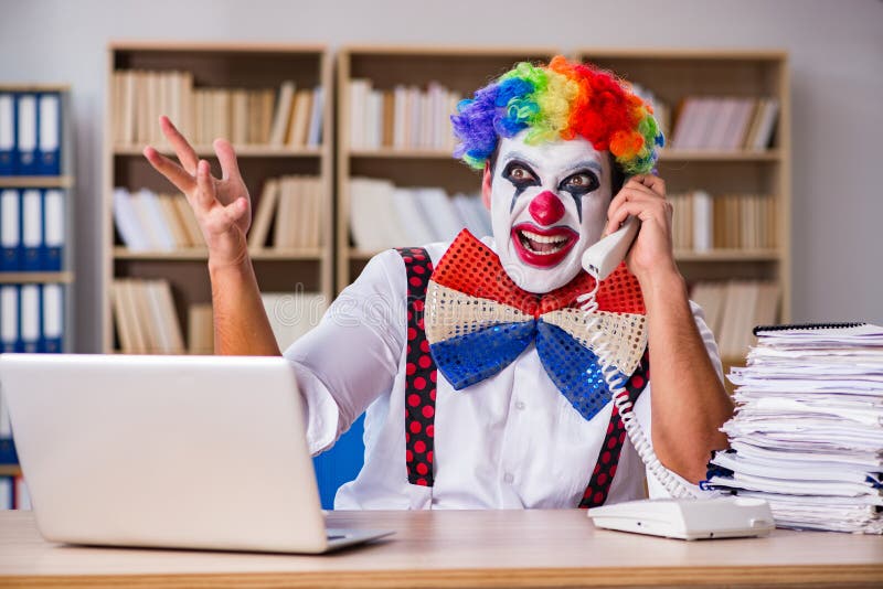 L'uomo d'affari del pagliaccio che lavora nell'ufficio fotografie stock libere da diritti L'uomo d'affari del pagliaccio che lavora nell'ufficio fotografie stock libere da diritti