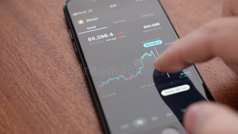 L'uomo d'affari sta controllando il grafico dei prezzi di Bitcoin sullo schermo di iphone