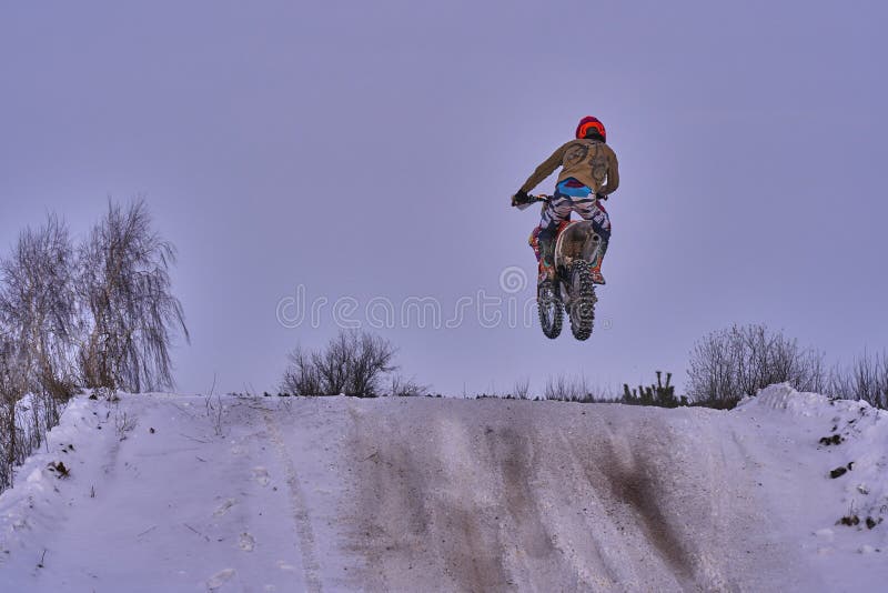 L'uomo del corridore dello sportivo compie un giro veloce su un motociclo sull'estremo della strada La pista di corsa è molto irr fotografie stock L'uomo del corridore dello sportivo compie un giro veloce su un motociclo sull'estremo della strada La pista di corsa è molto irr fotografie stock
