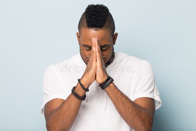 L'uomo di colore promettente si tiene per mano nella speranza di preghiera per fortuna