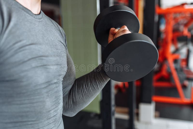 L'uomo di sport solleva i pesi nell'addestramento nella palestra, primo piano delle mani fotografia stock libera da diritti L'uomo di sport solleva i pesi nell'addestramento nella palestra, primo piano delle mani fotografia stock libera da diritti