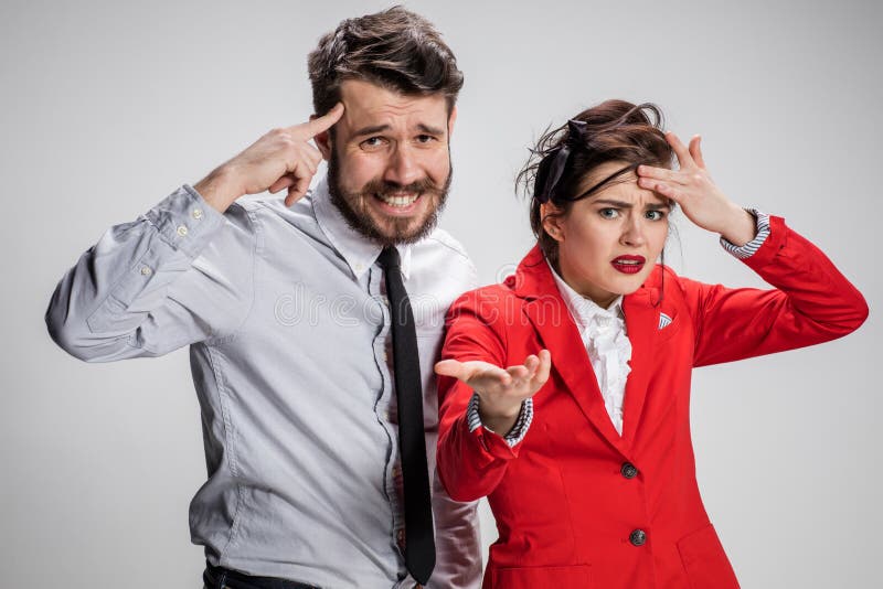L'uomo e la donna di affari che comunicano su un fondo grigio immagini stock libere da diritti L'uomo e la donna di affari che comunicano su un fondo grigio immagini stock libere da diritti