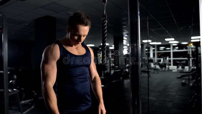 L'uomo forte che prepara per l'allenamento dei muscoli del braccio, tricipite cabla l'esercizio di pushdown immagini stock L'uomo forte che prepara per l'allenamento dei muscoli del braccio, tricipite cabla l'esercizio di pushdown immagini stock