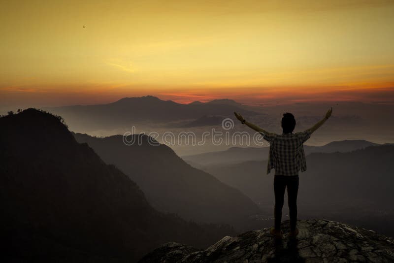 L'uomo gode della libertà alla montagna fotografie stock libere da diritti L'uomo gode della libertà alla montagna fotografie stock libere da diritti