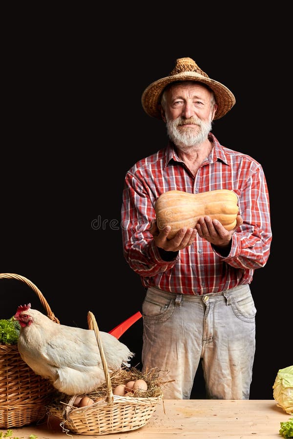 L'uomo maturo del villaggio, mostrante appena ha preso la zucca fresca dalla sua serra fotografia stock libera da diritti L'uomo maturo del villaggio, mostrante appena ha preso la zucca fresca dalla sua serra fotografia stock libera da diritti