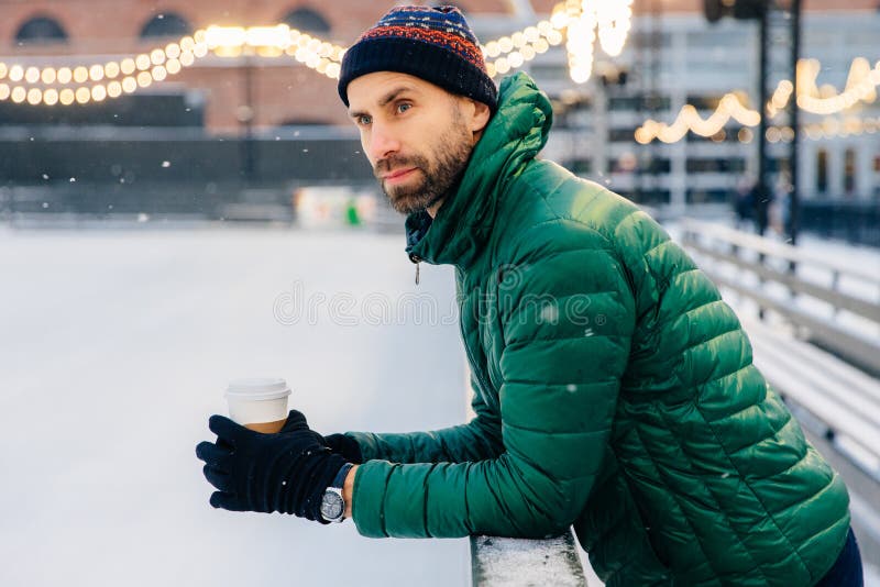 L'uomo premuroso con la barba spessa pende al quindi, tiene la c asportabile immagine stock L'uomo premuroso con la barba spessa pende al quindi, tiene la c asportabile immagine stock