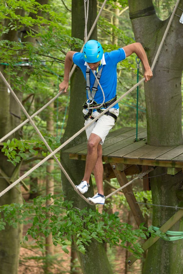 Man climbing over obstacles at high rope court. Man climbing over obstacles at high rope court