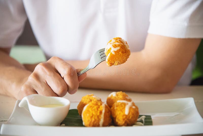 L'uomo sta andando mangiare la palla del formaggio fritta allungamento appiccicoso immagini stock libere da diritti L'uomo sta andando mangiare la palla del formaggio fritta allungamento appiccicoso immagini stock libere da diritti