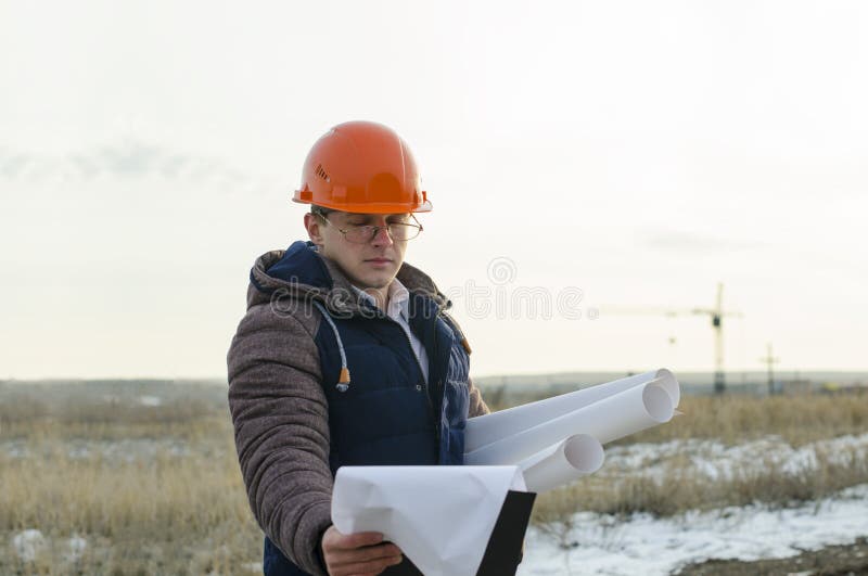 L'usage De Travailleur D'homme Un Casque Orange Avec Le Chantier De  Construction Photo stock - Image du gens, masculin: 85694508