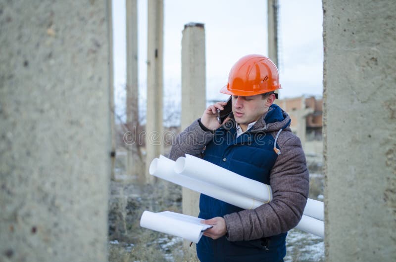 L'usage De Travailleur D'homme Un Casque Orange Avec Le Chantier De  Construction Photo stock - Image du gens, masculin: 85694508