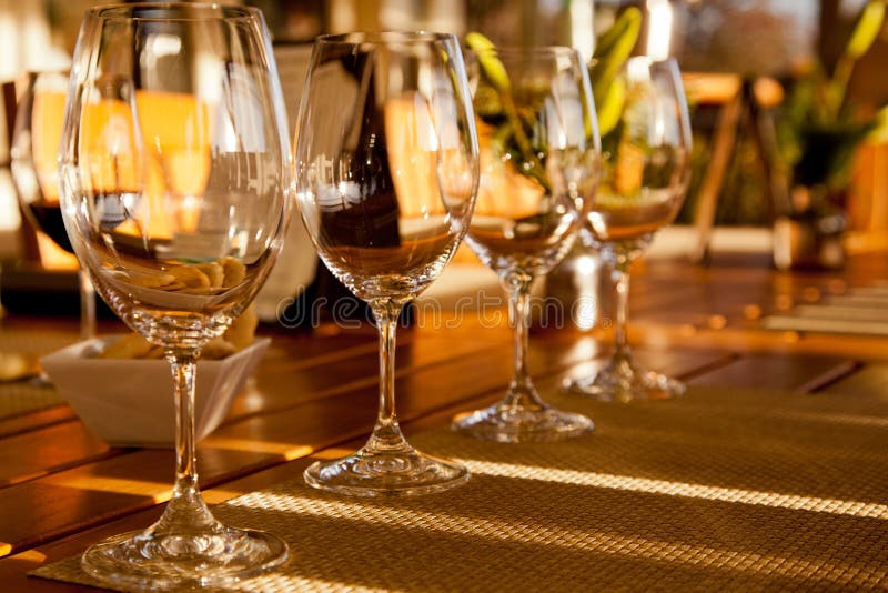 Crystal glasses are ready for a summer wine tasting on the patio of a home. Crystal glasses are ready for a summer wine tasting on the patio of a home