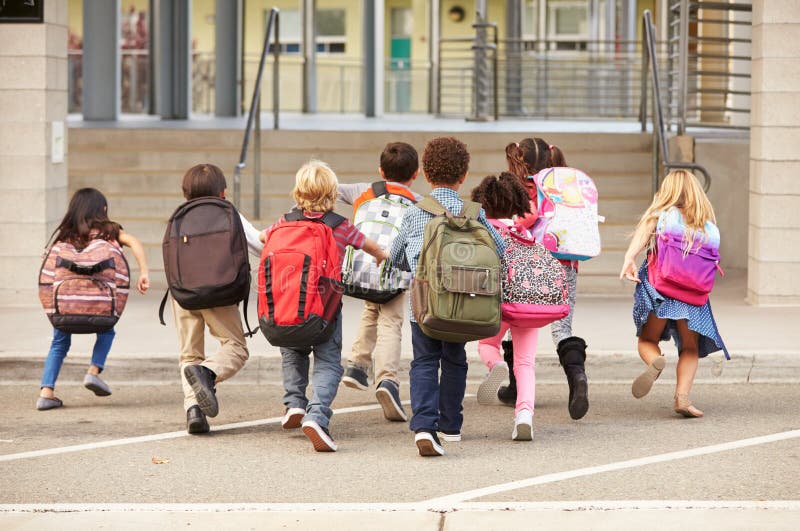 L'école primaire badine le fonctionnement dans l'école, vue arrière images stock L'école primaire badine le fonctionnement dans l'école, vue arrière images stock
