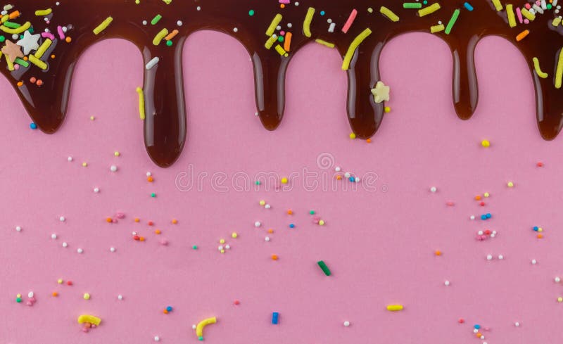 L'écrimage de gâteau de chocolat arrose avec du chocolat circulant vers le bas sur le fond rose photographie stock L'écrimage de gâteau de chocolat arrose avec du chocolat circulant vers le bas sur le fond rose photographie stock