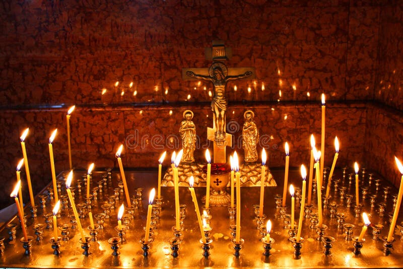 L'église bougies allumées dans un bougeoir doré dans un lieu de culte dans l'obscurité. La cire jaune a allumé des bougies se tien
