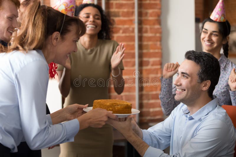 L'équipe excitée félicitent le collègue dans le bureau faisant le cadeau d'anniversaire image stock L'équipe excitée félicitent le collègue dans le bureau faisant le cadeau d'anniversaire image stock