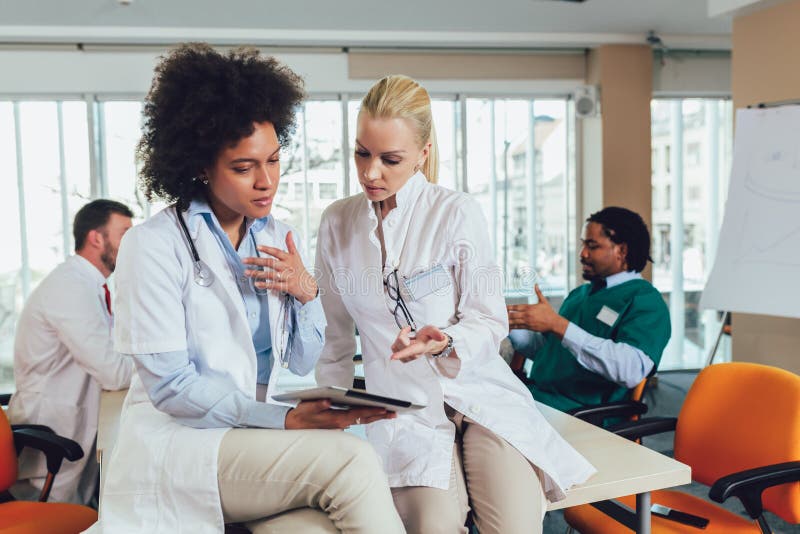 L'équipe médicale et discutant assis à la table photos stock