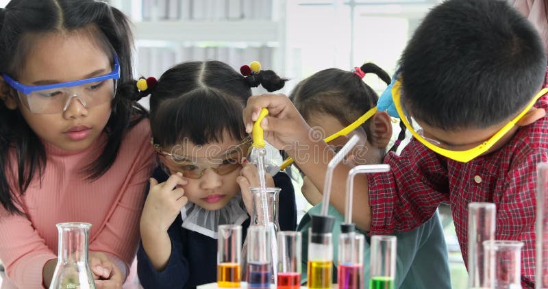 L'étudiant laissent tomber quelque chose dans le tube coloré, dans le laboratoire