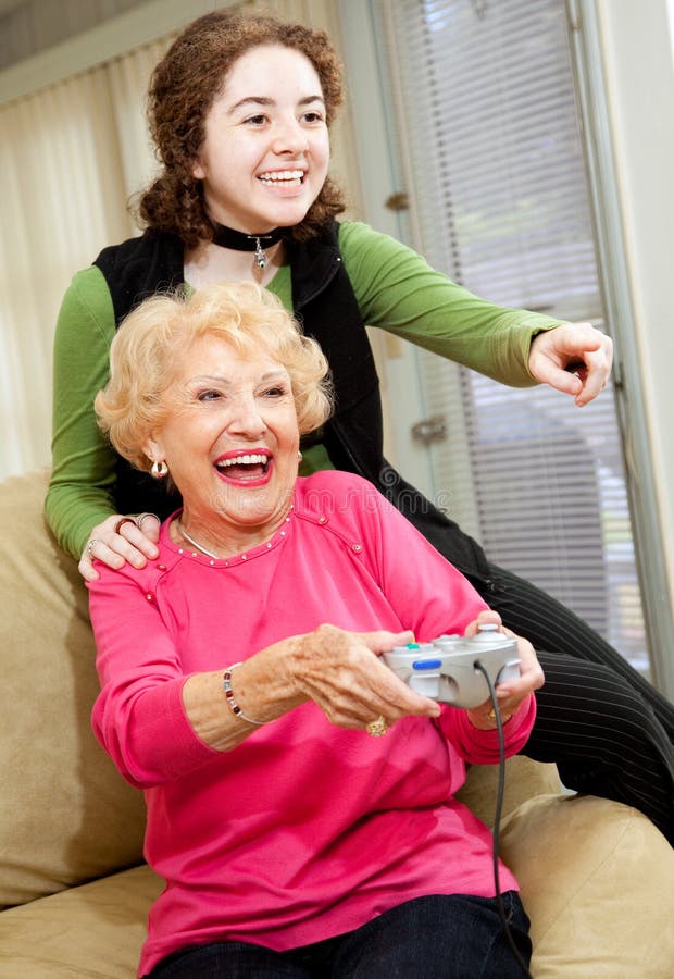 Grandmother and teen granddaughter having a great time playing video games. Grandmother and teen granddaughter having a great time playing video games.