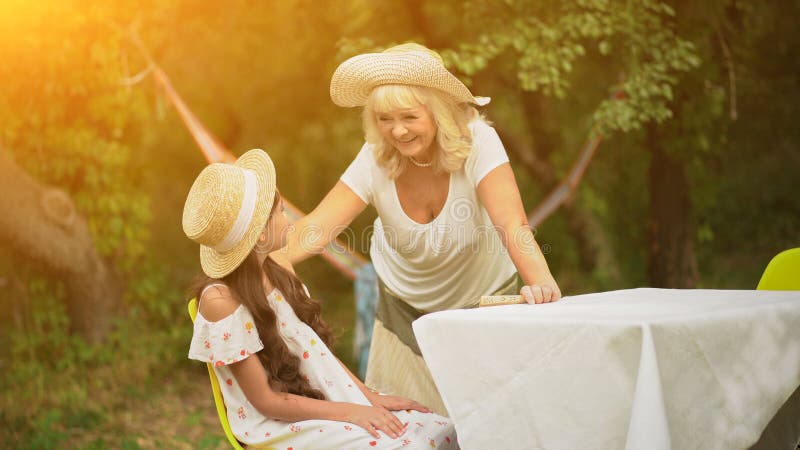 La Abuela Y La Nieta Están En La Tabla En El Jardín Imagen De Archivo Imagen De Sentada