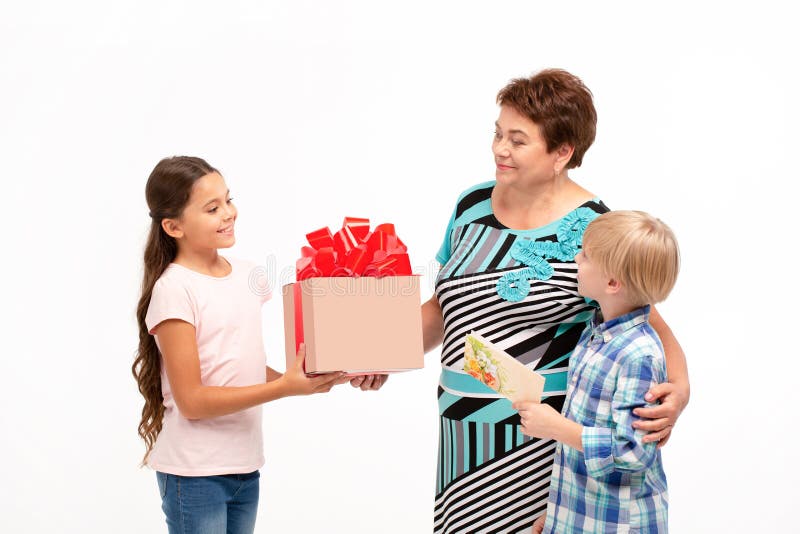 La abuela y sus nietos que intercambian los regalos foto de archivo libre de regalías La abuela y sus nietos que intercambian los regalos foto de archivo libre de regalías