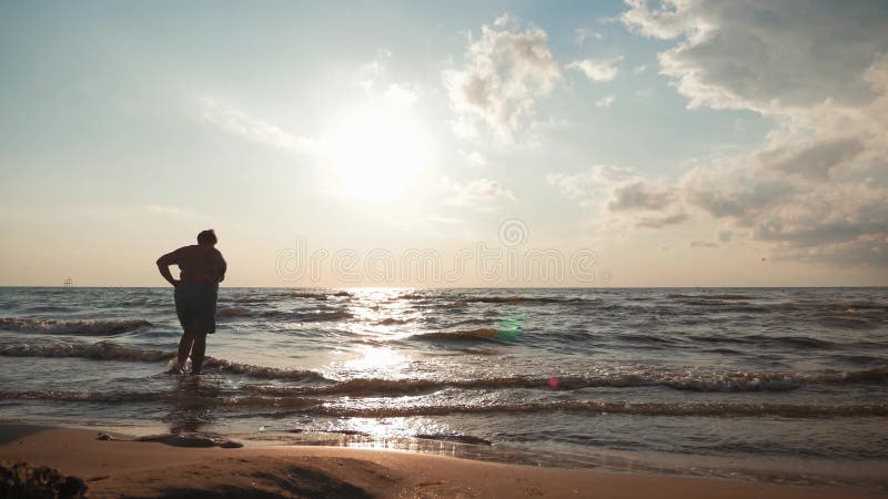 La anciana Silhouette estÃ¡ de pie en la playa y en el mar con una vida feliz despuÃ©s de su retiro. Viajes y jubilaciÃ³n